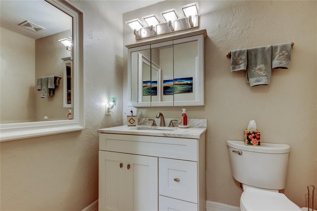 1407 Lennox Road East, Unit 1407 Palm Harbor, FL 34683 - Photo 27 of 48 a bathroom with a toilet sink and mirror