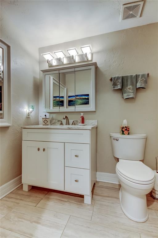 1407 Lennox Road East, Unit 1407 Palm Harbor, FL 34683 - Photo 28 of 48 a bathroom with a toilet sink and mirror