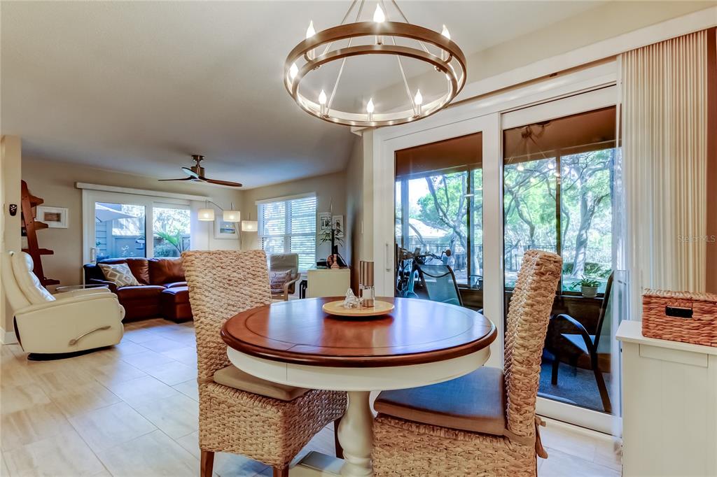 1407 Lennox Road East, Unit 1407 Palm Harbor, FL 34683 - Photo 6 of 48 a dining room with furniture wooden floor and a chandelier