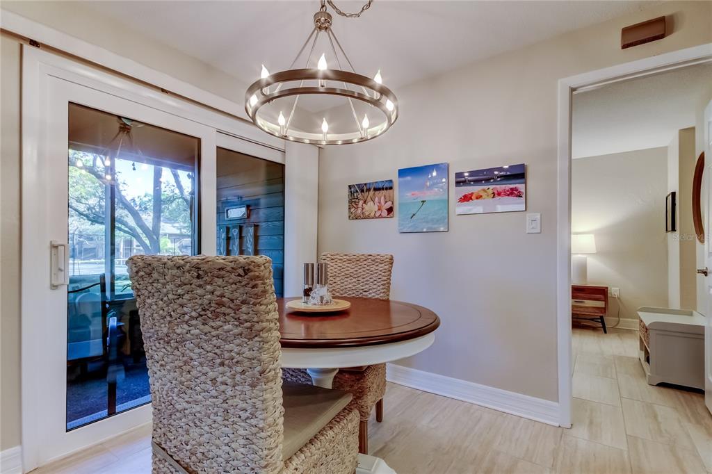 1407 Lennox Road East, Unit 1407 Palm Harbor, FL 34683 - Photo 7 of 48 a dining room with furniture a chandelier and wooden floor