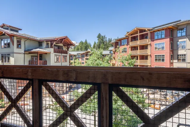 a front view of a building with a garden and balcony