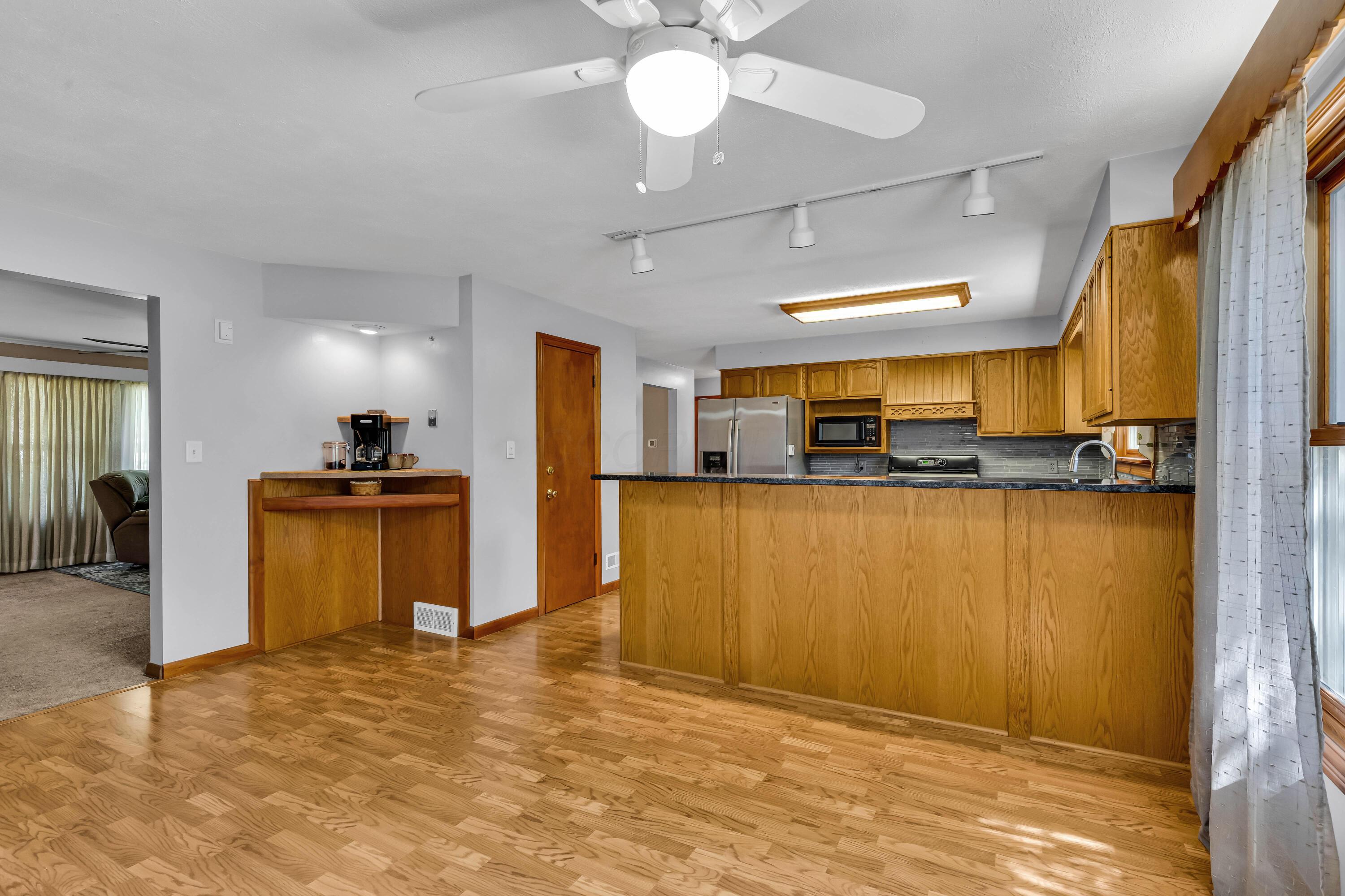 1213 East Cooke Road Columbus, OH 43224 - Photo 18 of 57 • Laminate flooring • Tan painted walls • Lighted ceiling fan • Corner wall shelf