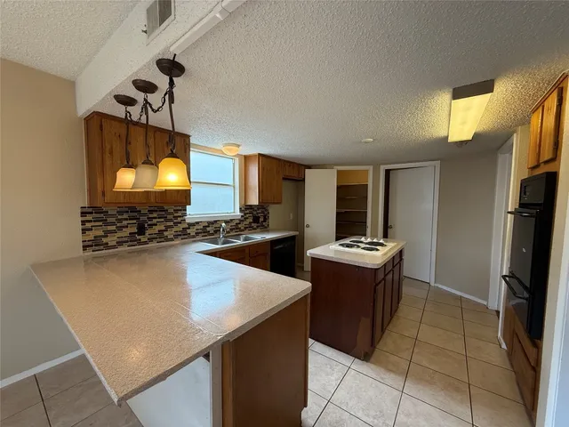 a kitchen with stainless steel appliances granite countertop a sink and a stove