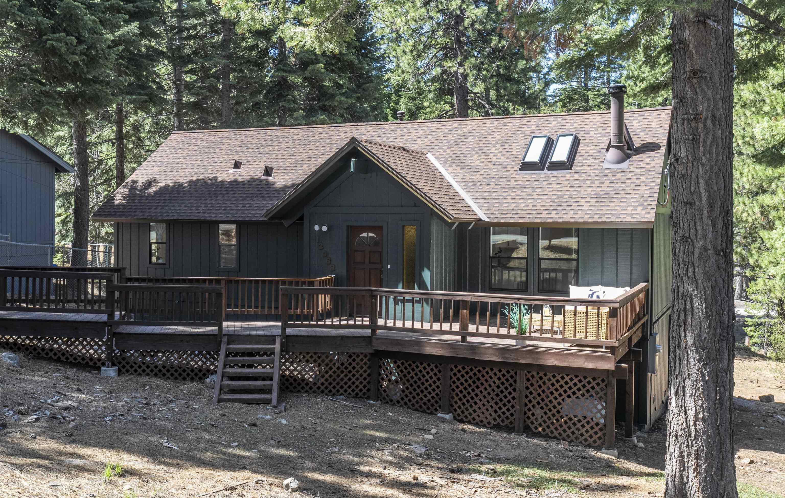 a view of house with a deck and a garden