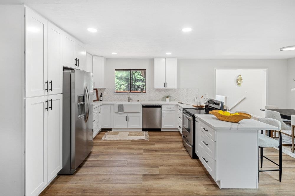 12068 Pine Forest Road Truckee, CA 96161 - Photo 10 of 27 a kitchen with stainless steel appliances a stove a refrigerator and white cabinets
