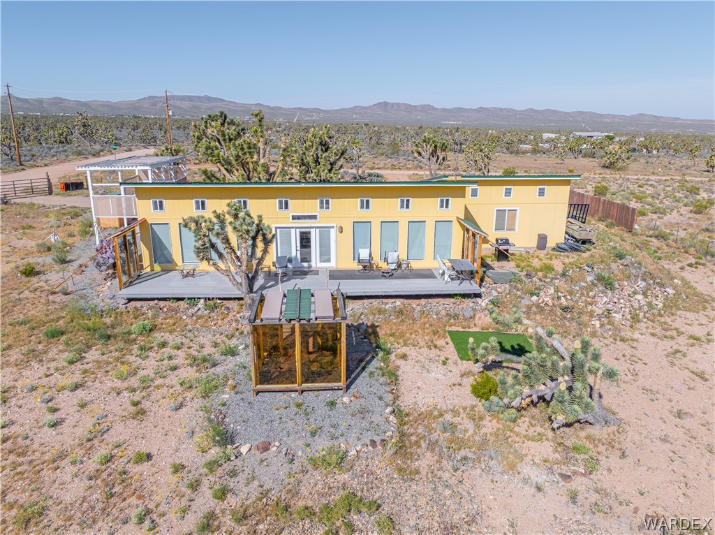 26512 North Yucca Road Meadview, AZ 86444 - Photo 1 of 38 The property features a yellow exterior and a flat roof, complemented by a spacious deck