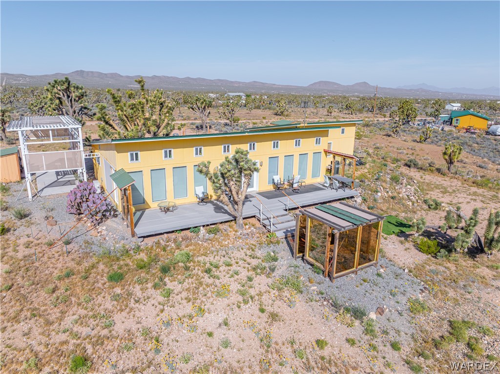 26512 North Yucca Road Meadview, AZ 86444 - Photo 11 of 38 The property features a single-story yellow exterior with a flat roof and a spacious deck