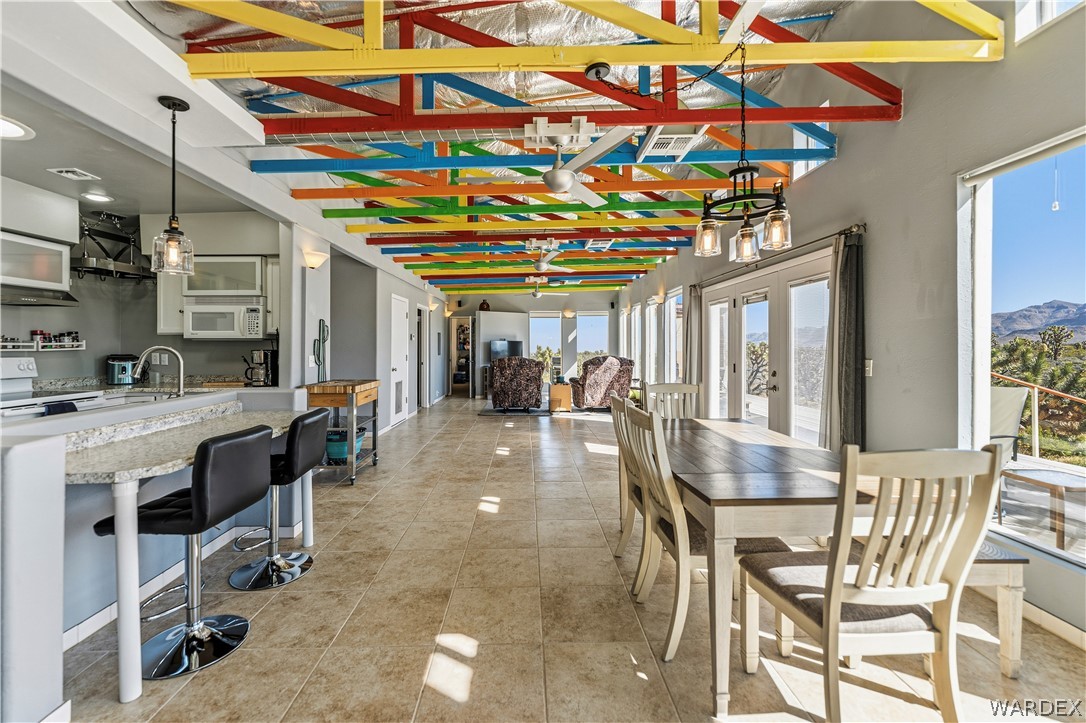 26512 North Yucca Road Meadview, AZ 86444 - Photo 22 of 38 This open-concept living area features tile flooring, a kitchen with white cabinetry and direct access to outdoor spaces through glass doors
