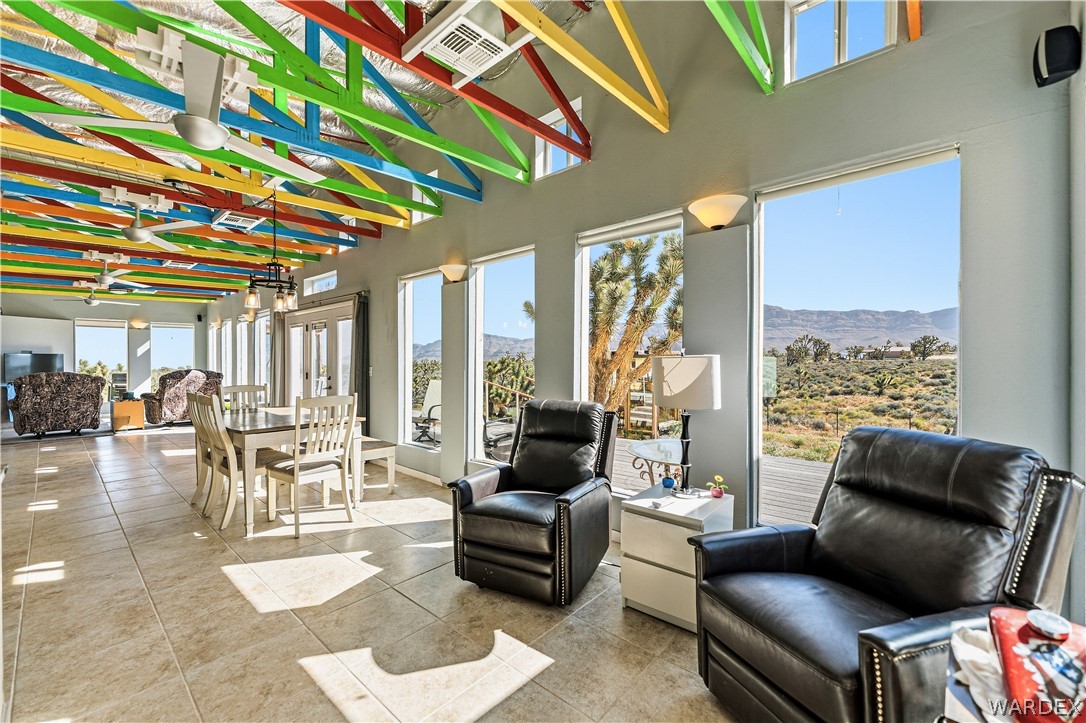 26512 North Yucca Road Meadview, AZ 86444 - Photo 23 of 38 Expansive living area featuring tiled flooring, large windows providing abundant natural light, and a dining area with a table and chairs