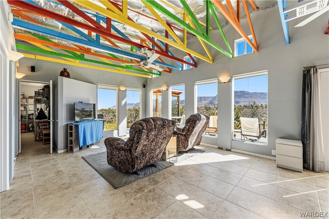 26512 North Yucca Road Meadview, AZ 86444 - Photo 24 of 38 The property features an interior with an exposed ceiling truss system in vibrant colors, a ceiling fan, and tiled flooring