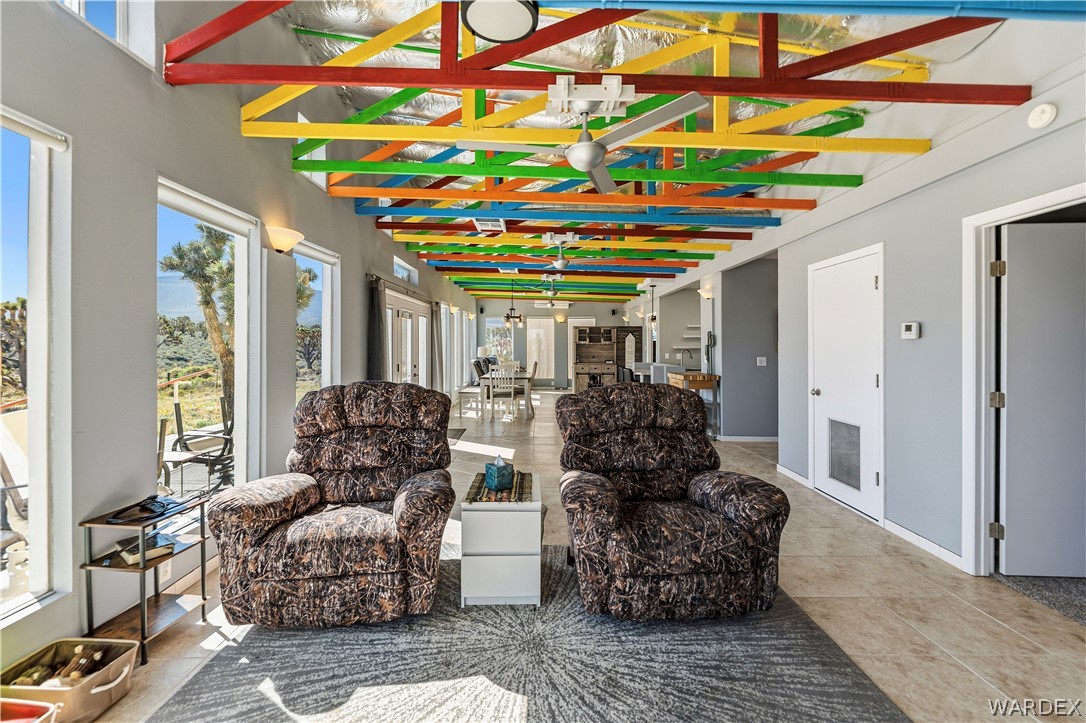 26512 North Yucca Road Meadview, AZ 86444 - Photo 26 of 38 This bright living space features large windows that offer views of the natural landscape, alongside a ceiling with exposed, multi-colored beams