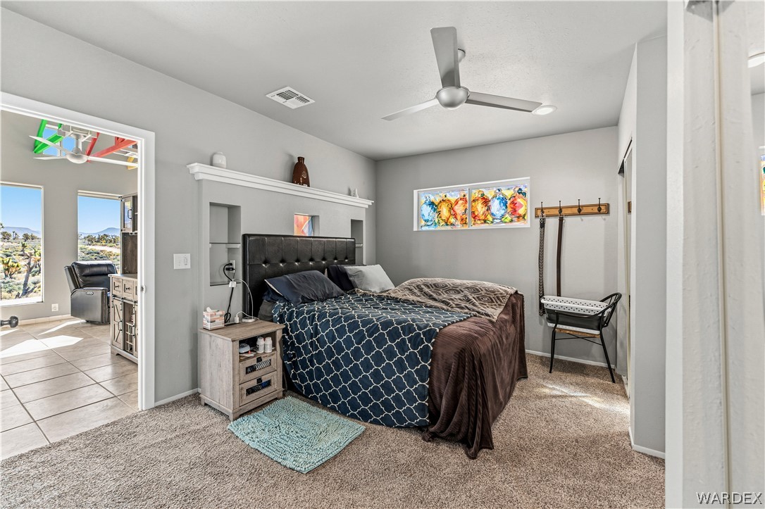 26512 North Yucca Road Meadview, AZ 86444 - Photo 28 of 38 This room features carpeted flooring, a ceiling fan, and built-in shelving above the bed