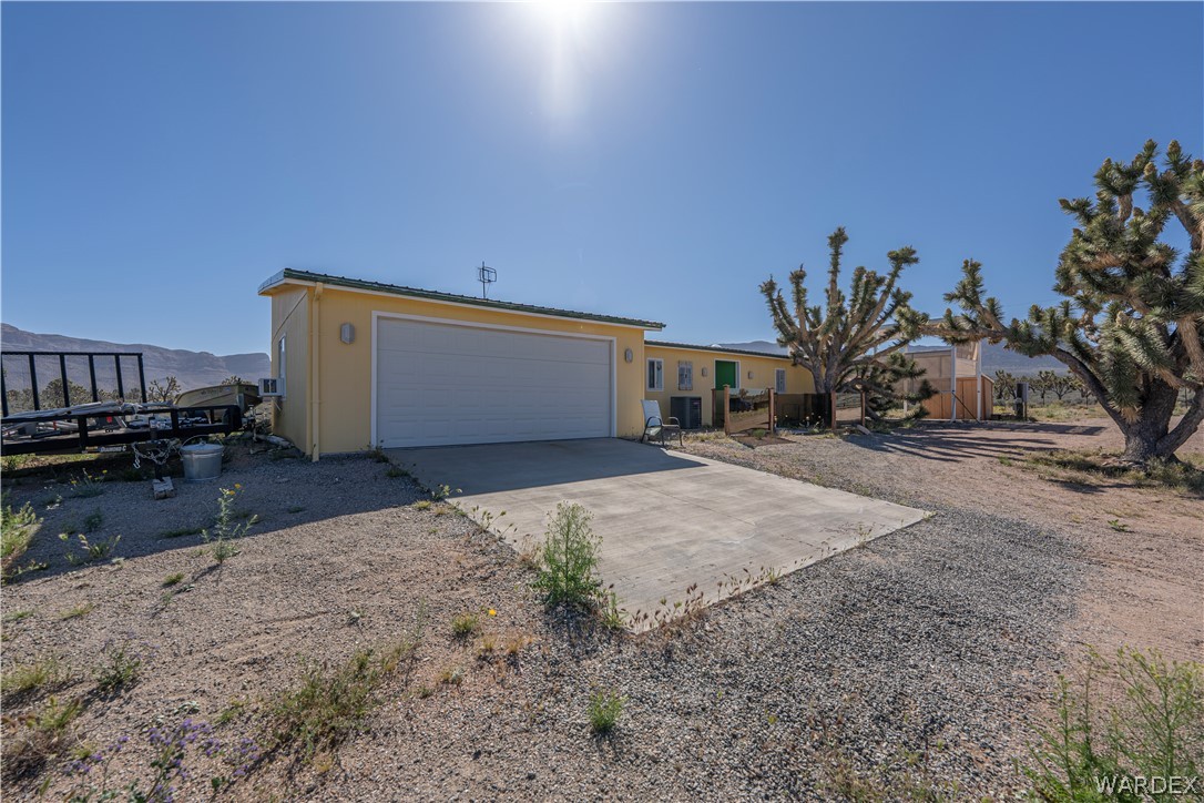 26512 North Yucca Road Meadview, AZ 86444 - Photo 34 of 38 The property features a yellow exterior and an attached garage with a concrete driveway