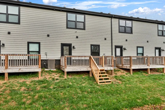 a view of a house with backyard and deck