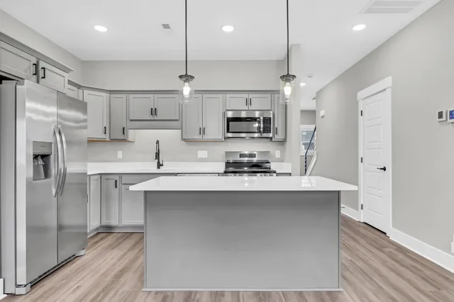 a kitchen with kitchen island a sink stainless steel appliances and cabinets