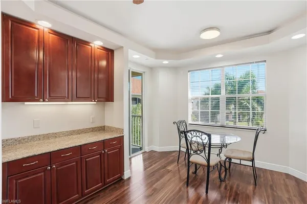 a kitchen with granite countertop wooden floors and wooden cabinets