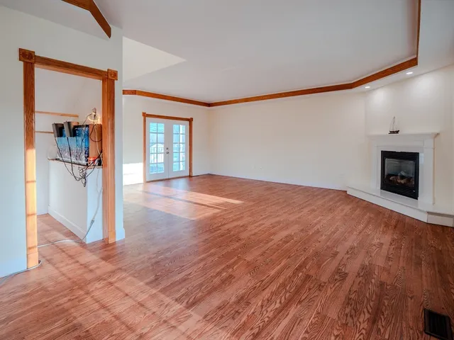a view of a room with wooden floor and a fireplace