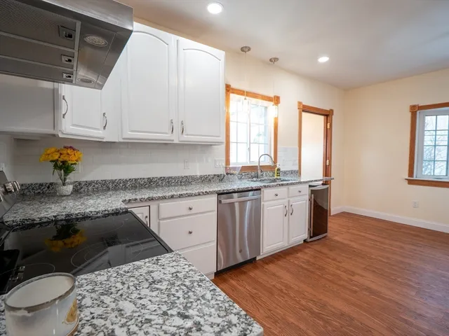 a kitchen with a sink wooden cabinets and white appliances