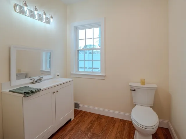 a bathroom with a toilet a sink and mirror