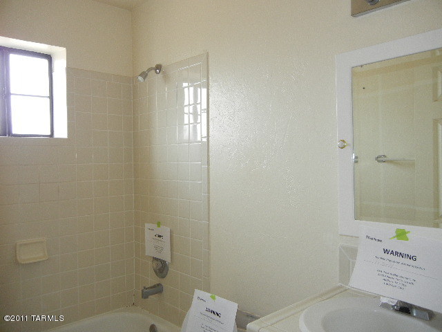 402 Moneda Court Rio Rico, AZ 85648 - Photo 8 of 10 a bathroom with a shower a toilet and sink