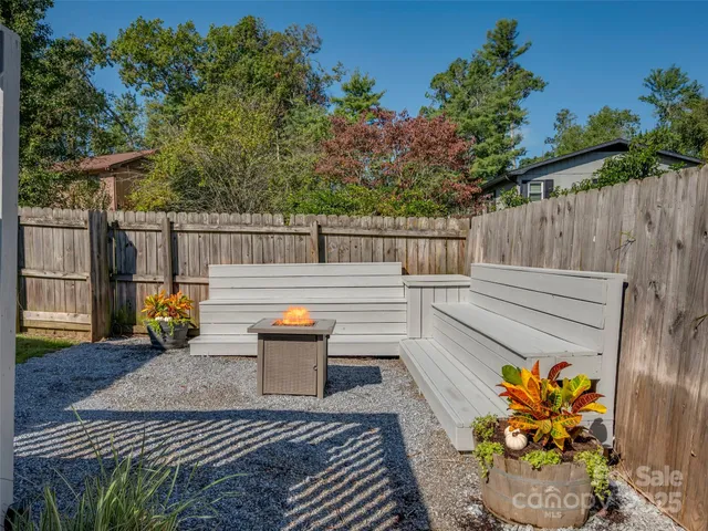 a backyard of a house with table and chairs potted plants with wooden floor