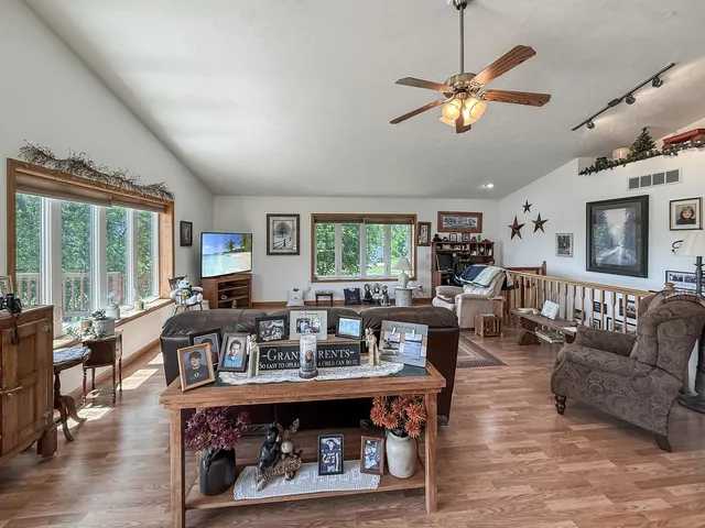 a living room with furniture kitchen view and a large window