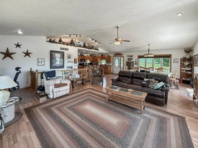a living room with furniture kitchen view and a large window