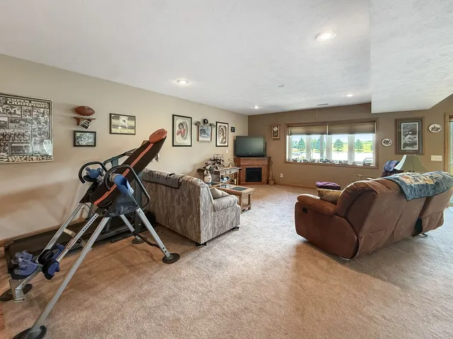 a living room with furniture and a gym machine next to a window