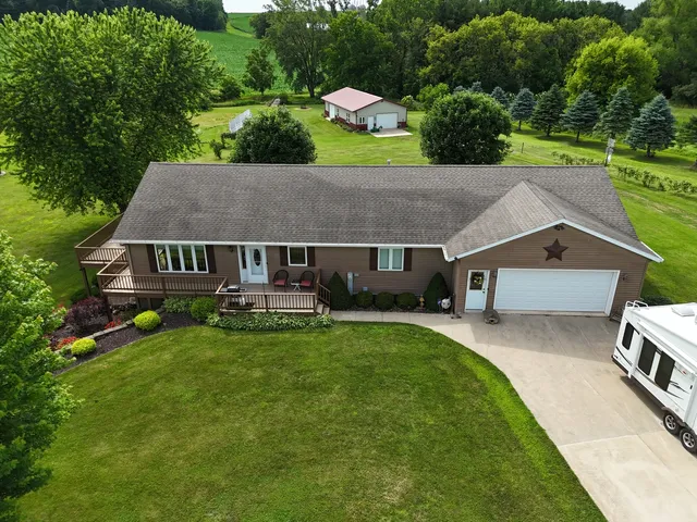 a aerial view of a house with swimming pool next to a big yard