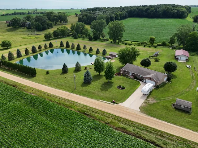 a aerial view of a house with swimming pool next to a big yard