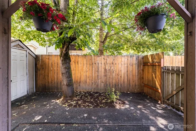 an empty room with wooden floor chandelier and windows