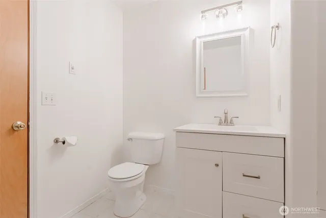 a bathroom with a toilet a sink a vanity and mirror