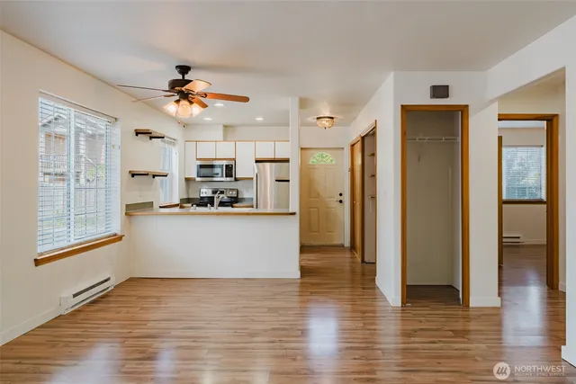 a view of a kitchen with wooden floor and a ceiling fan