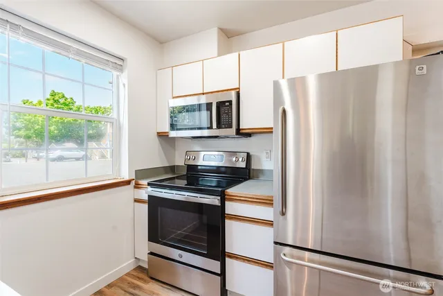a kitchen with stainless steel appliances a refrigerator sink and microwave