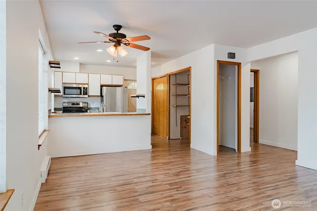a view of a kitchen with wooden floor and a ceiling fan
