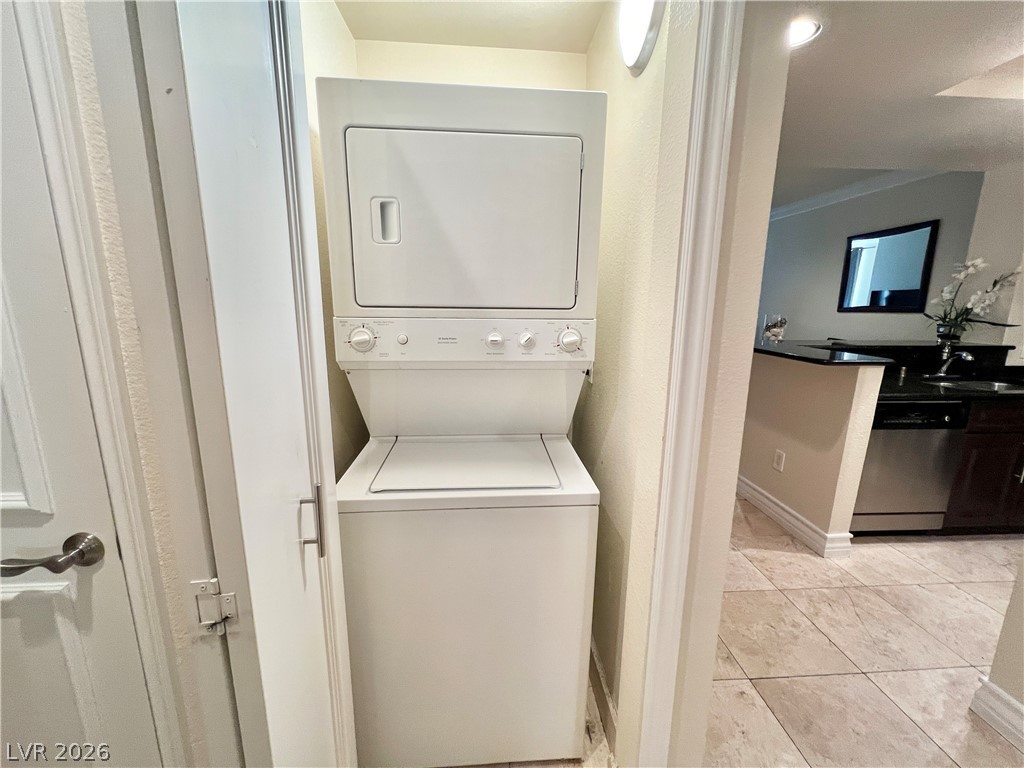 270 East Flamingo Road, Unit 313 Las Vegas, NV 89169 - Photo 13 of 27 A compact laundry center with stacked appliances integrates seamlessly into the hall, adjacent to a well-appointed kitchen.