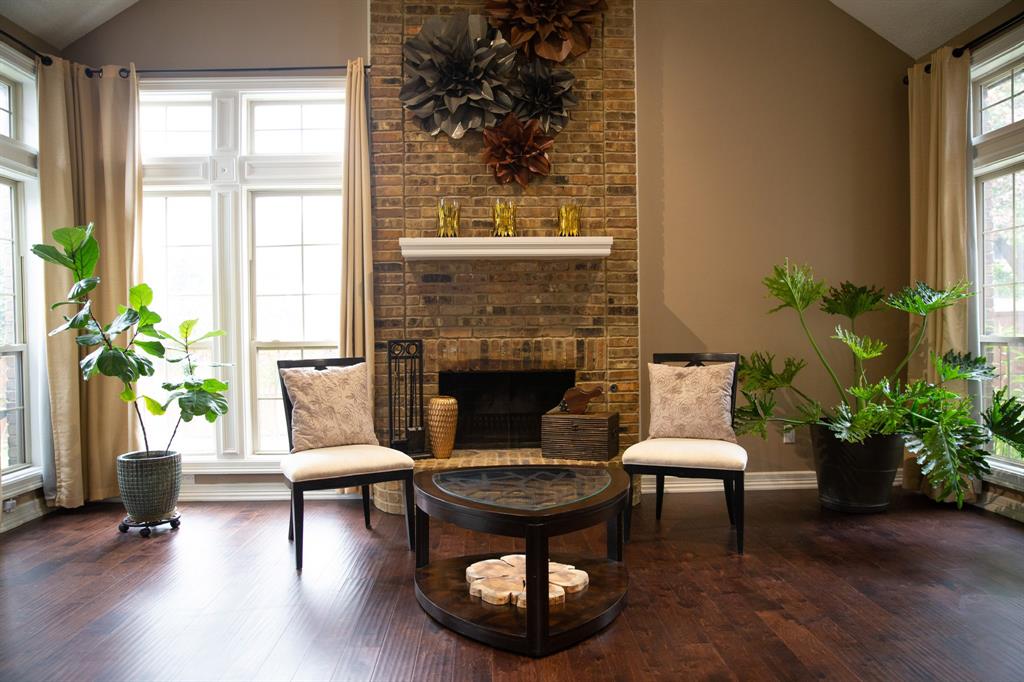 a living room with furniture a potted plant and a fireplace
