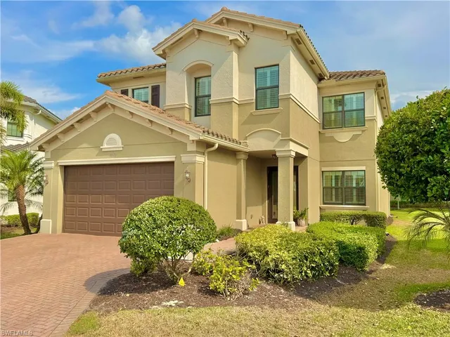 a view of a house with a yard and a large tree