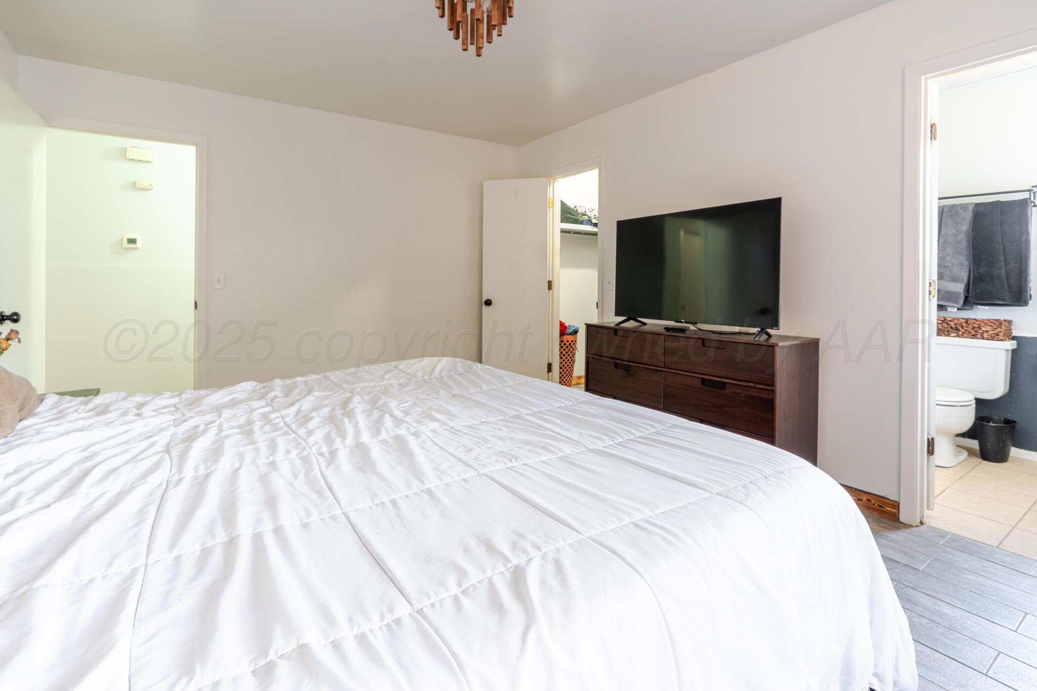 5210 South Milam Street Amarillo, TX 79110 - Photo 12 of 22 a bedroom with a bed and a flat screen tv