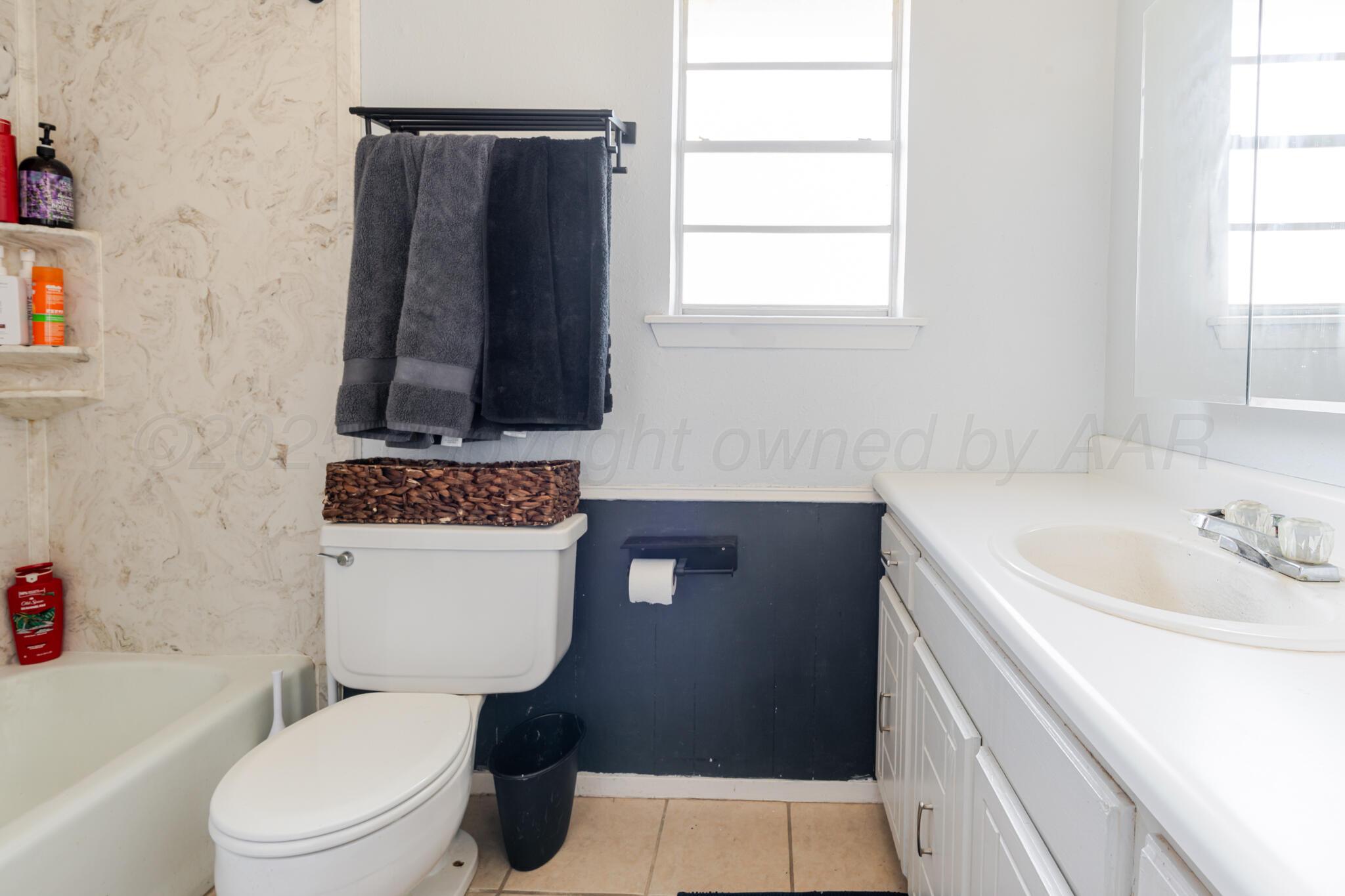 5210 South Milam Street Amarillo, TX 79110 - Photo 13 of 22 a bathroom with a toilet sink and mirror
