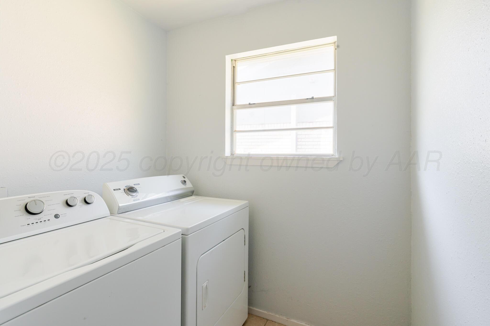 5210 South Milam Street Amarillo, TX 79110 - Photo 19 of 22 a view of washer and dryer with bathroom in the background