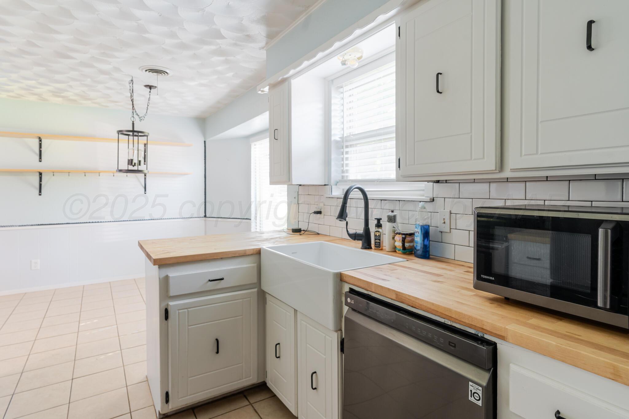 5210 South Milam Street Amarillo, TX 79110 - Photo 5 of 22 a kitchen with a sink stove and cabinets
