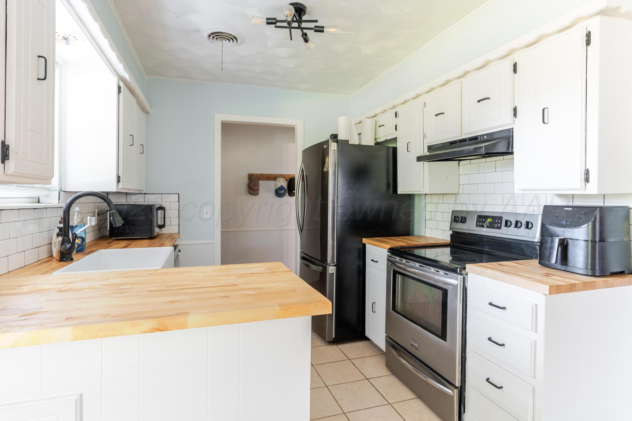 5210 South Milam Street Amarillo, TX 79110 - Photo 7 of 22 a kitchen with a stove a refrigerator and a sink