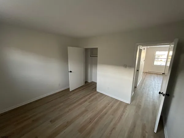 an empty room with wooden floor and mirror
