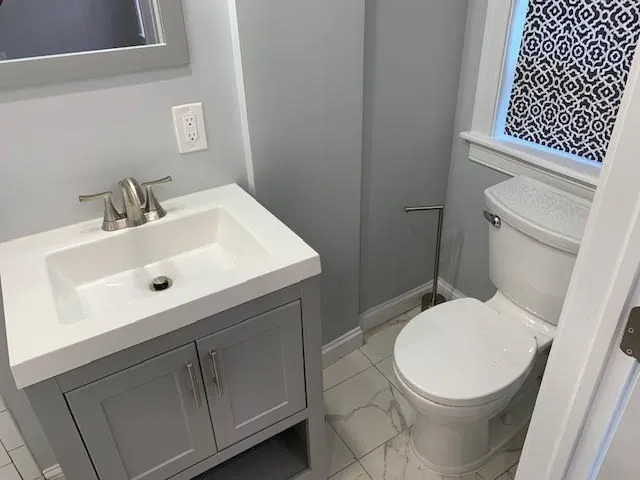 a white toilet sitting next to a bathroom sink