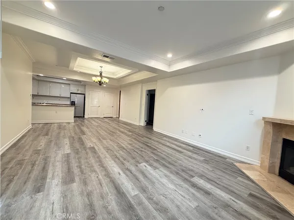 a kitchen with stainless steel appliances granite countertop a refrigerator a stove a sink a microwave and white cabinets with wooden floor