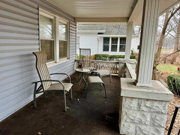 a white house that has tree in front of it