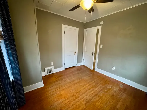 a view of empty room with wooden floor