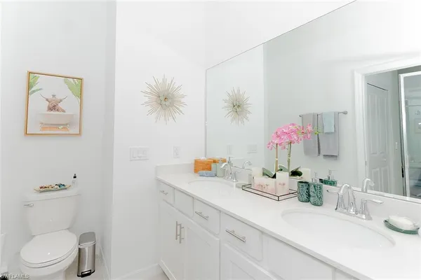 a bathroom with a granite countertop sink a toilet and a mirror