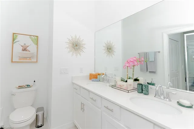 a bathroom with a granite countertop sink a toilet and a mirror